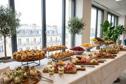 Table de buffet traiteur professionnel dans un espace événementiel parisien moderne avec charcuterie, verrines et sandwiches élégants